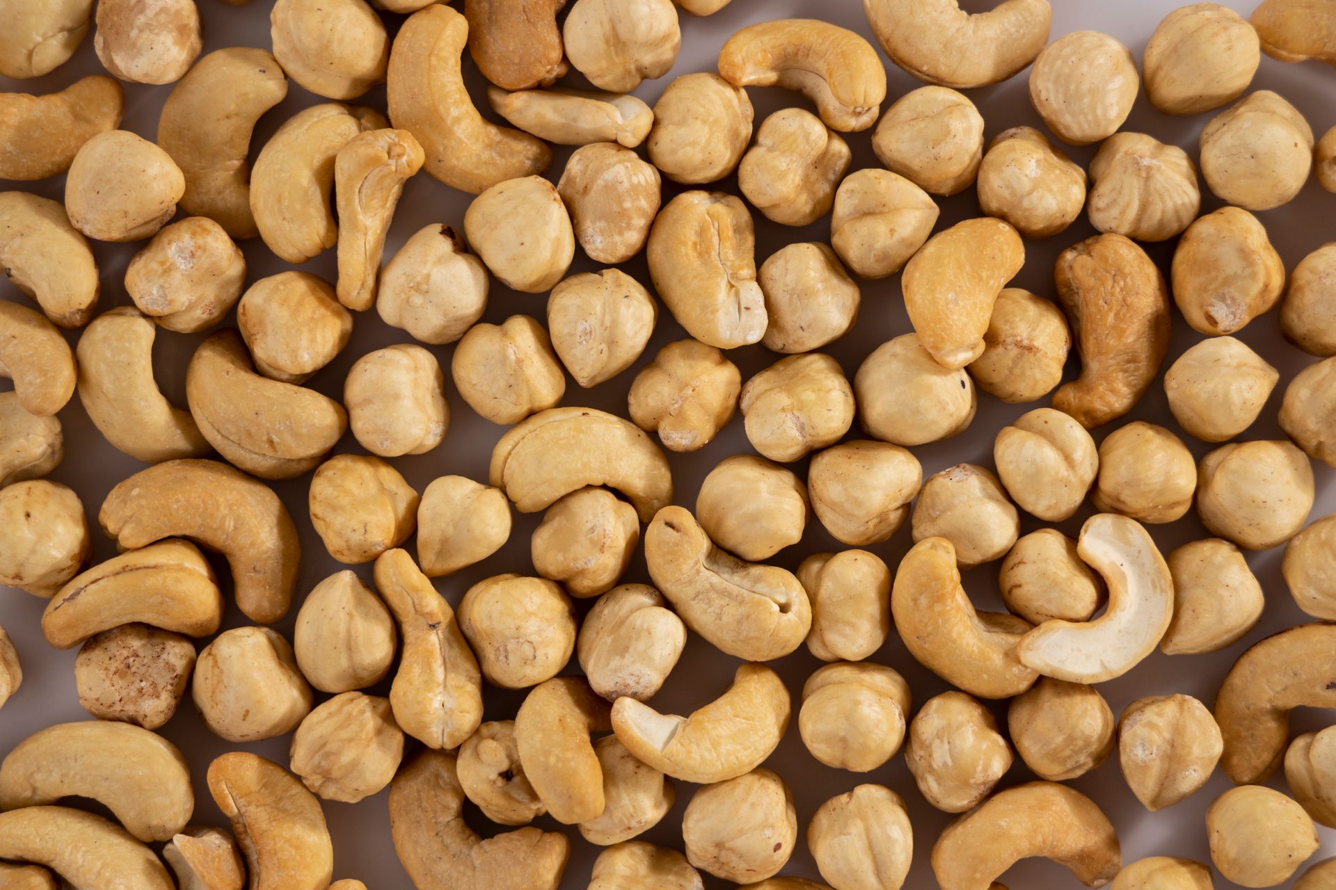 Close-up of shelled macadamia and cashew nuts in a pile