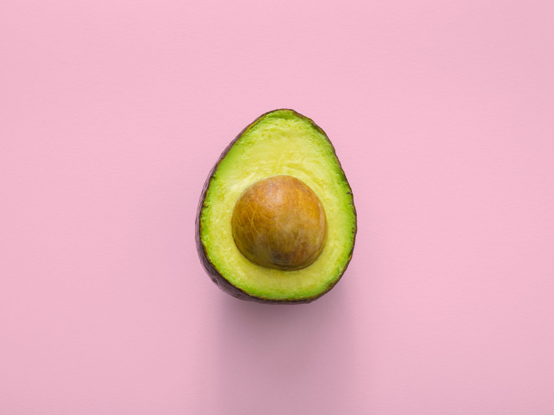Sliced avocado halves with the large pit visible